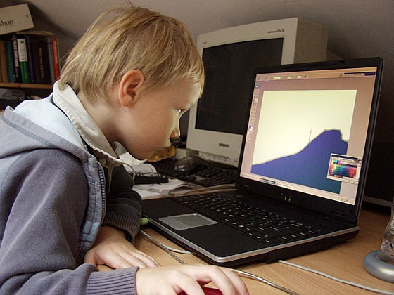 Marceli als Kind 2005 vor einem Laptop mit geöffnetem Photoshop